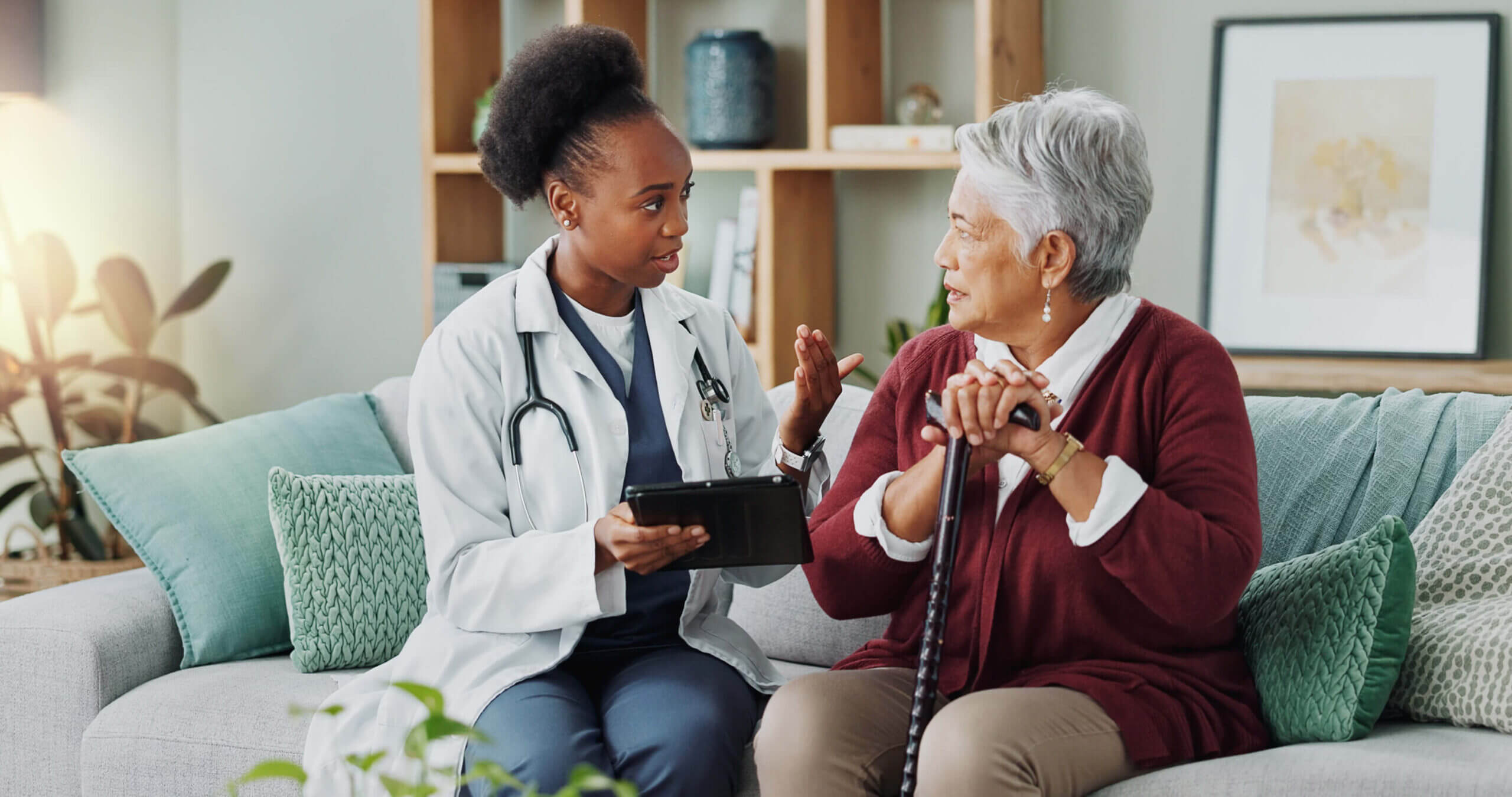 Doctor showing information on a tablet to an elderly patient